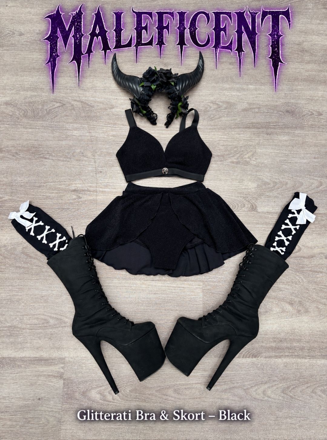 Maleficent inspired Halloween pole costume flat lay with the RARR Glitterati Bra and Skort in Black, horned headpiece, bone print socks and platform boots